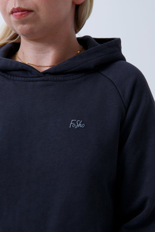 A woman wearing dark grey hoodie and leggings on a white background
