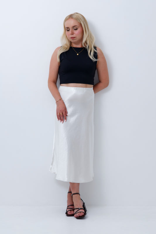 A woman wearing cream satin midi skirt for petite women, on a white background

